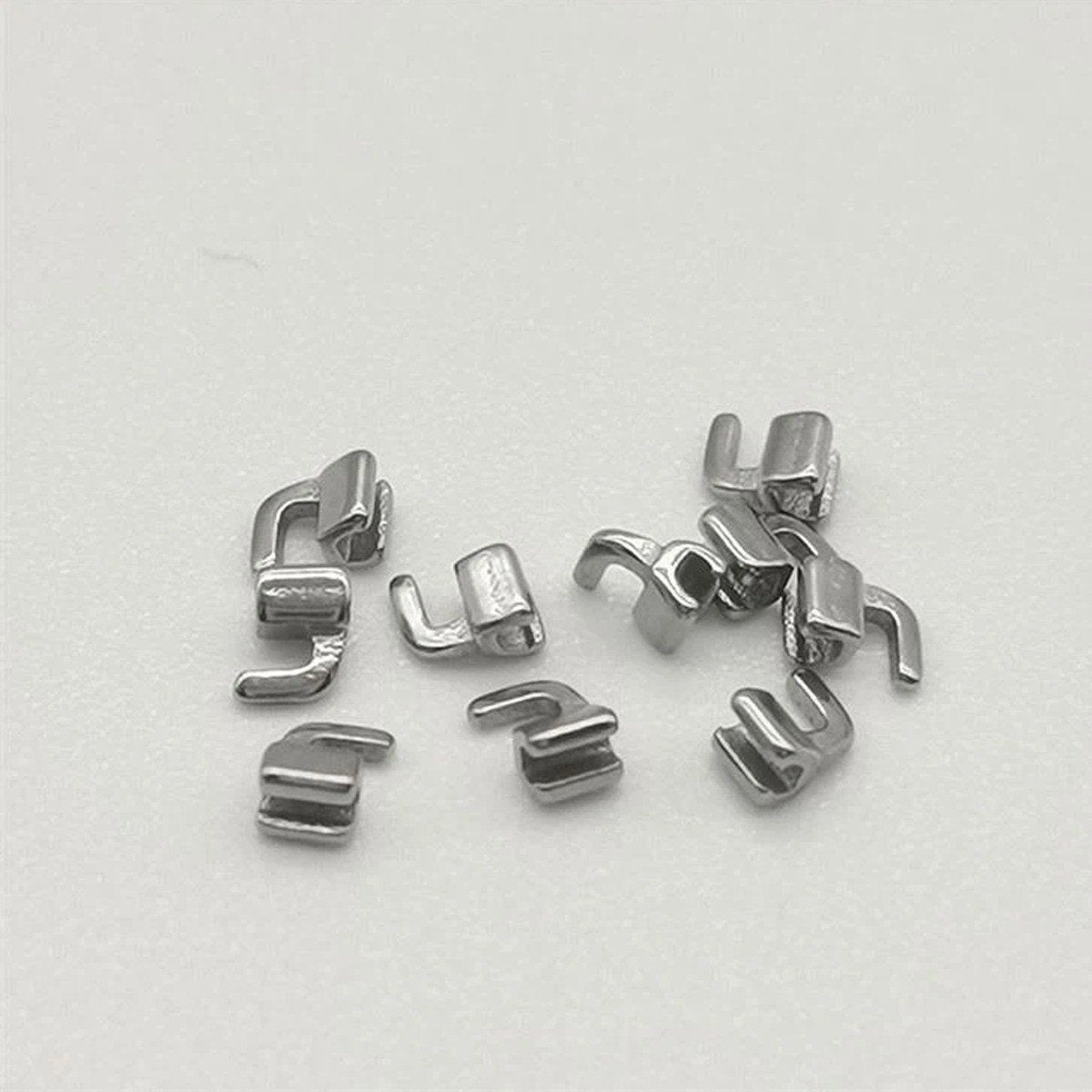 Captain Orthodontics Captain Mini Curved Bondable Crimpable Hooks for orthodontic adjustments, shown in a close-up image.