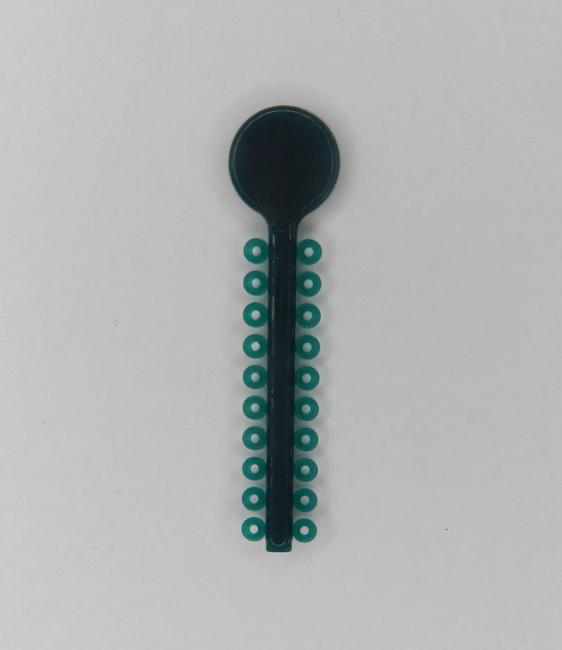 White G&H Select Elastomeric Ligature Ties for orthodontic use, shown in a close-up view of the small, flexible ties on a tray