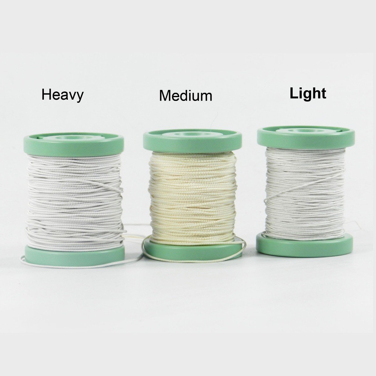 Light-colored Leone elastic ligatures made of cotton thread on a sleeve for dental or medical use.