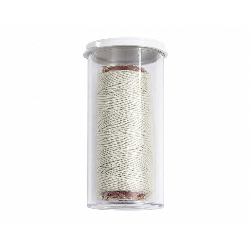 Light-colored TP Orthodontics elastic latex-free cotton thread sleeve and thread for orthodontic use.