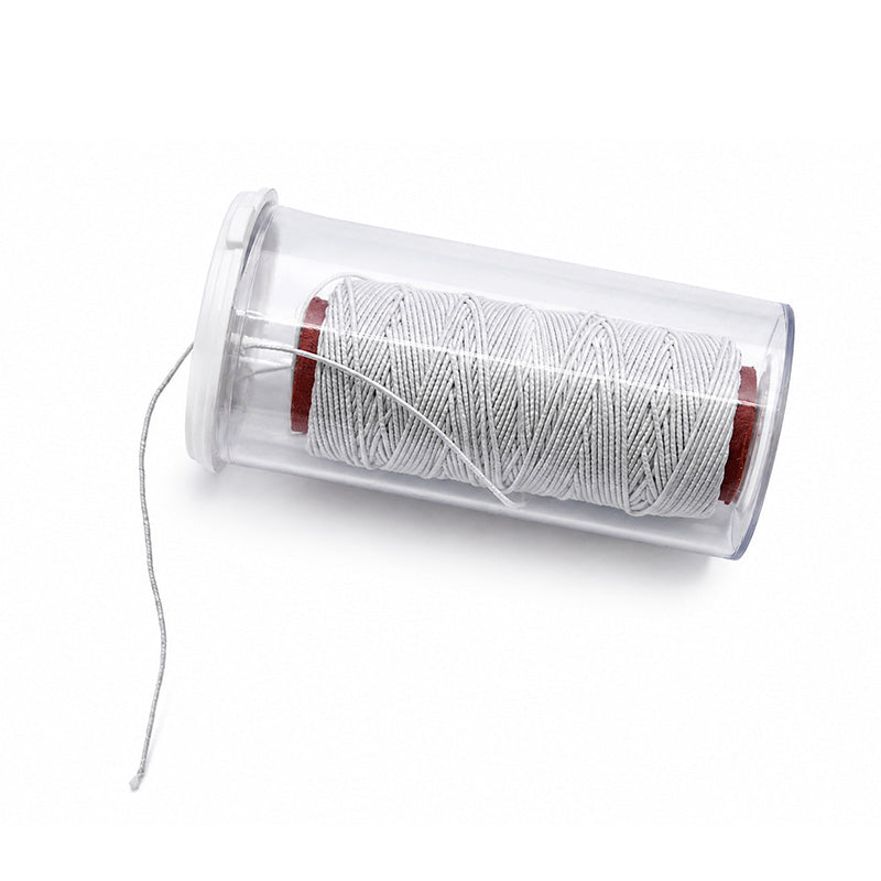 Light-colored TP Orthodontics elastic latex-free cotton thread sleeve and thread for orthodontic use.